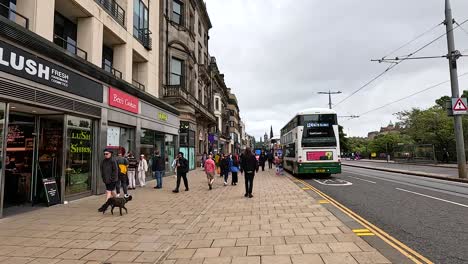 pedestrians and buses on a bustling street