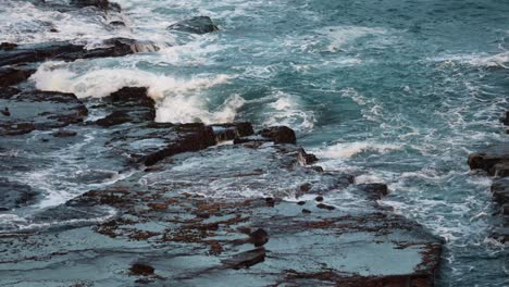 crashing waves breaks on the rocky shoreline