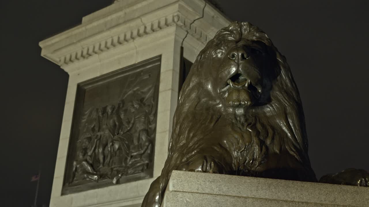 el famoso león de bronce en la plaza de trafalgar por la noche, londres en el reino unido