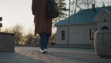 한 소녀가 흐릿한 공원에서 걸어가고 있으며, 은 그녀의 다리와 발에서 시작됩니다. 배경은 부드럽게 초점을 맞추지 않습니다.