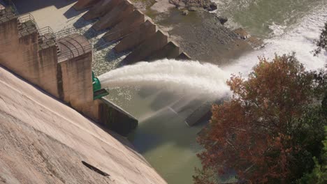 puerta de inundación de la presa hidroeléctrica con agua que fluye a través de la puerta