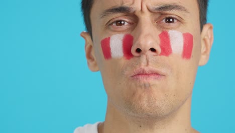 serious man with a peruvian flag painted on the face