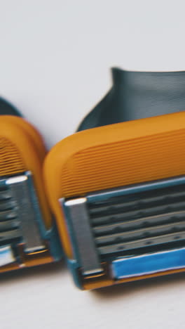 motion along line of cassettes for men shaving razor lying on clean white background extreme close view