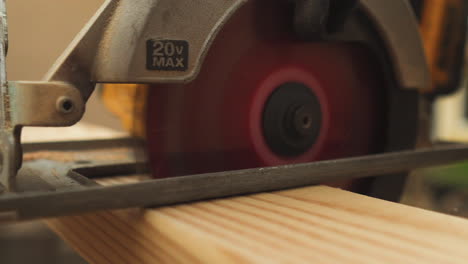 sawing wood board with circular saw, close up