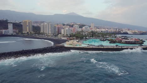 Aerial-view-towards-downtown-Puerto-de-la-cruz,-lago-Martianez-and-Mt-Teide