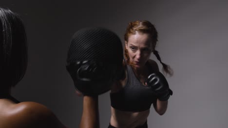 Studioaufnahme-Von-Zwei-Reifen-Frauen-In-Fitnesskleidung,-Die-Gemeinsam-Boxen-Und-Sparring-Trainieren-4