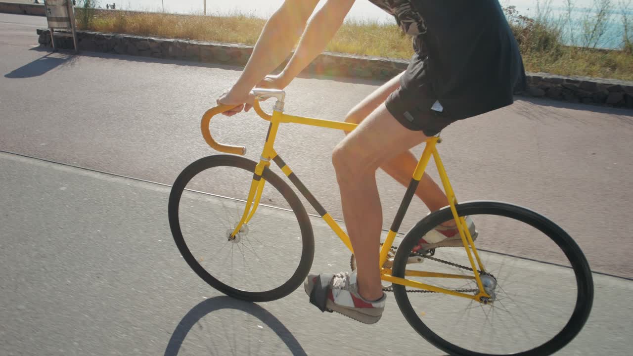 Person Cycling a Yellow Fixed Gear Bike on a Coastal Path