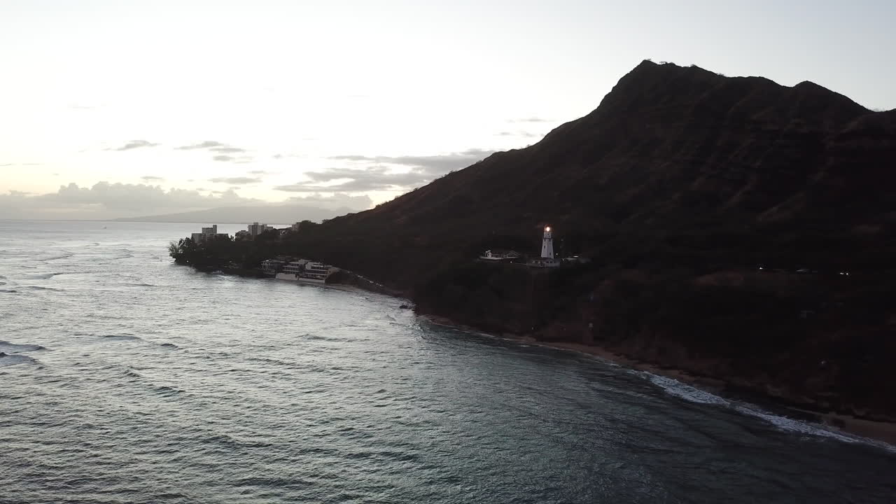 Tramonto che guarda verso Diamond Head e Waikiki a Oahu, Hawaii, con vista sul faro e sulle onde