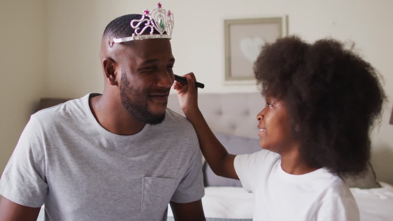 padre afroamericano con tiara con maquillaje puesto por su hija