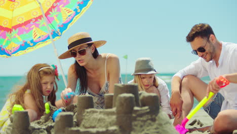 family building sandcastles at the beach