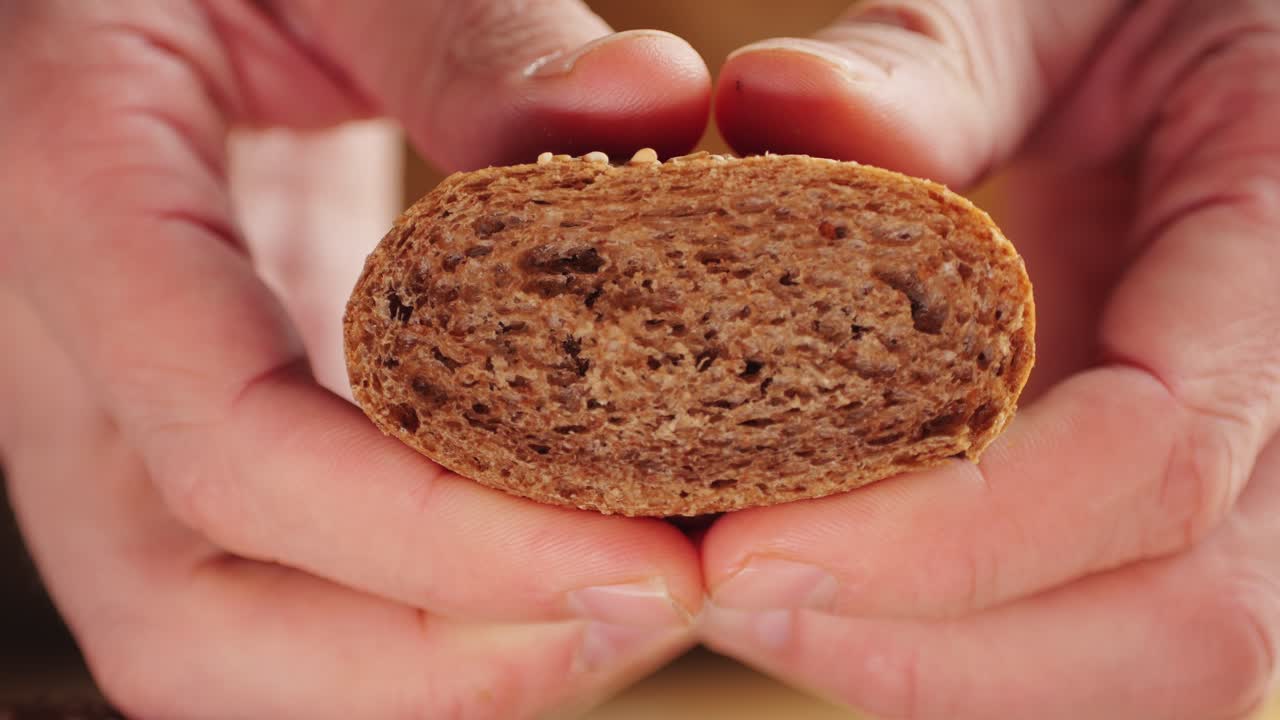 manos sosteniendo una rebanada de pan de trigo entero