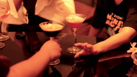 two hands interacting over a cocktail glass