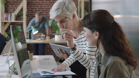 mature business leader woman training young intern using computer colleagues working collaborating brainstorming creative strategy in modern office workspace