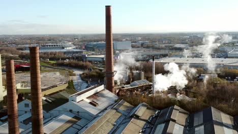 pilkington glass factory warehouse buildings aerial view circling above industrial chimney rooftop