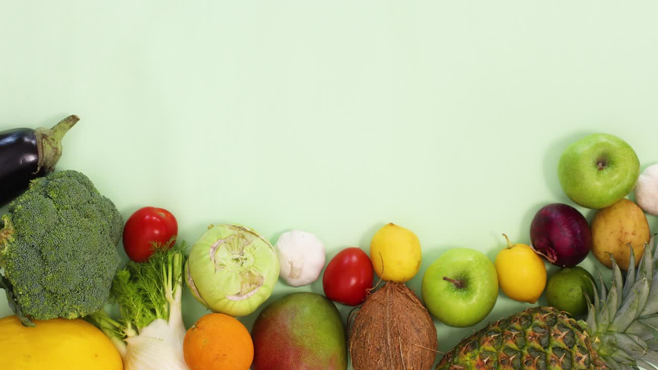 frutas y verduras orgánicas frescas clasificadas en la parte inferior del fondo verde claro.