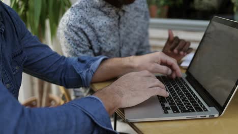 freelancers working with laptop in outdoor cafe