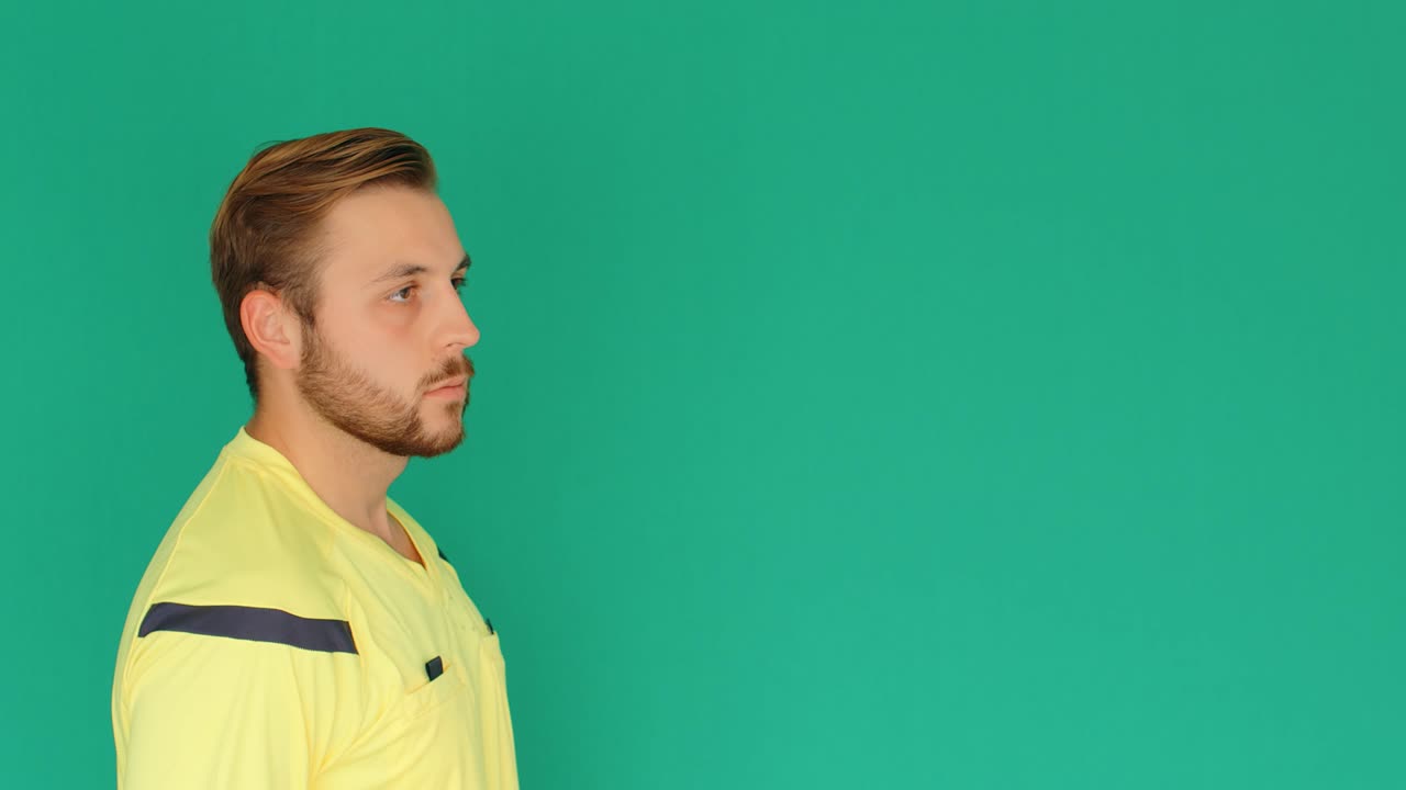 el árbitro de fútbol en la pantalla verde muestra la tarjeta amarilla de penalización, 4k