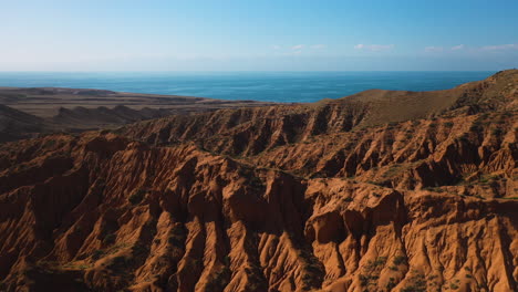 cinematic aerial shot flying over mountain ridges at fairy tale canyon near issyk-kul lake in karakol, kyrgyzstan