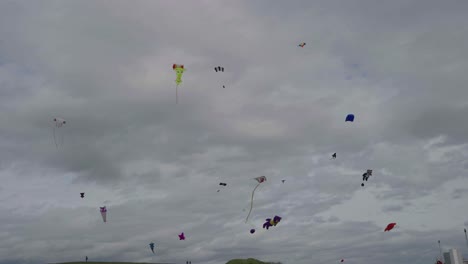 many colourful kites being flown high in the sky, slow motion footage