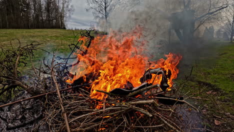 Big-bonfire-of-branches-burning-strong,-closing-in