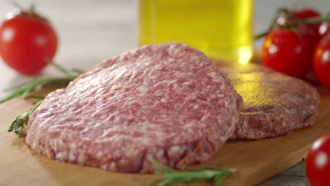 raw burger meat on a cutting board slowly rotates.