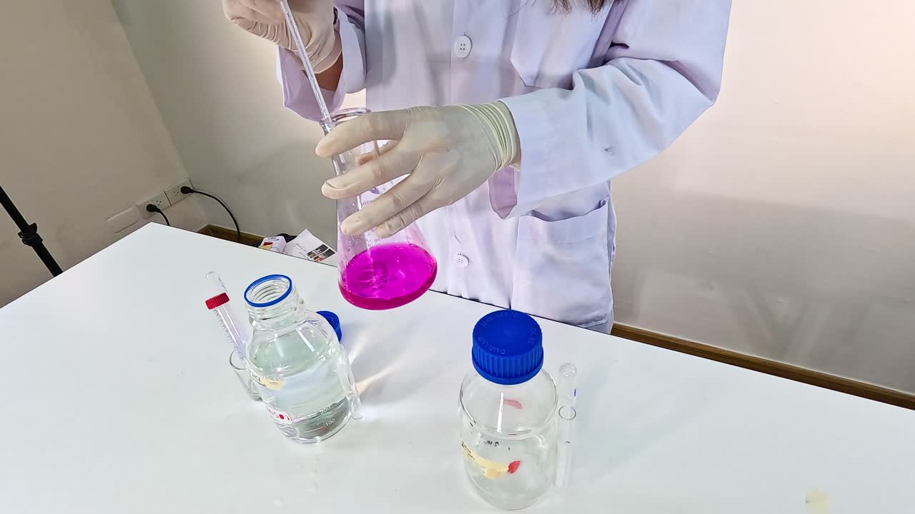 A scientist conducts a potassium permanganate reduction experiment in a lab setting, showcasing precise chemical handling and observation