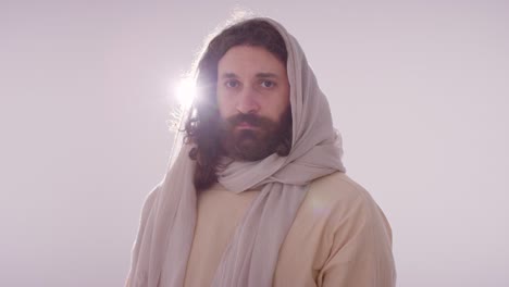 backlit portrait of man wearing robes with long hair and beard representing figure of jesus christ 2