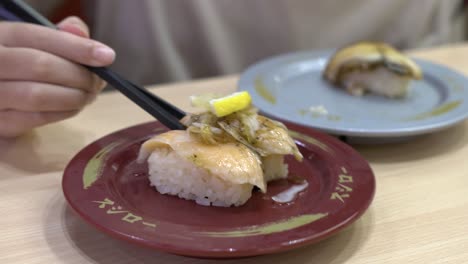 close-up sushi when a child girl uses chopsticks to get sushi to her mouth