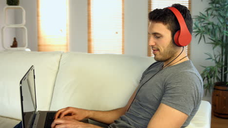 Man-using-his-laptop-on-the-couch