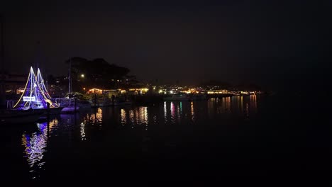 gimbal wide panning shot of restaurants and shops on the embarcadero at night in morro bay, california. 4k
