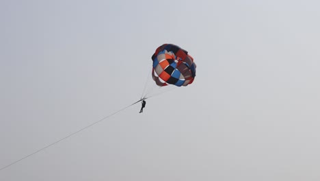 parasailing adventure activity with bright blue sky background at day from flat angle