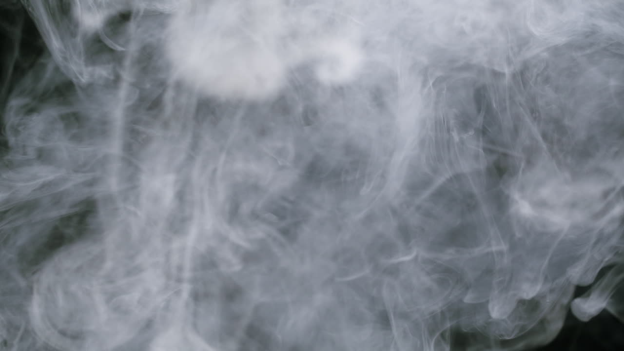 Dense White Smoke Swirling Against Black Background