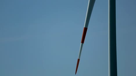 closeup slow rotating wind turbine with blue sky background concept green energy