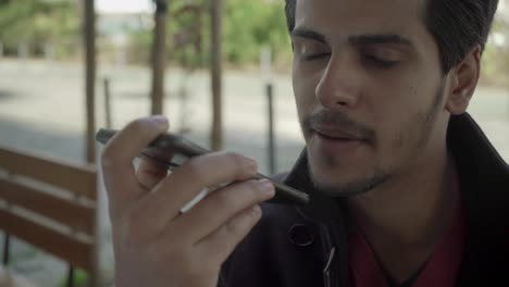 Young-man-holding-smartphone-and-answering-phone-call