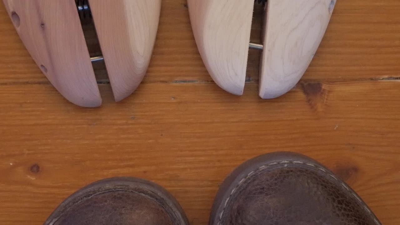 Shoe polishing tools and shoes on wooden floor, showcasing maintenance tools
