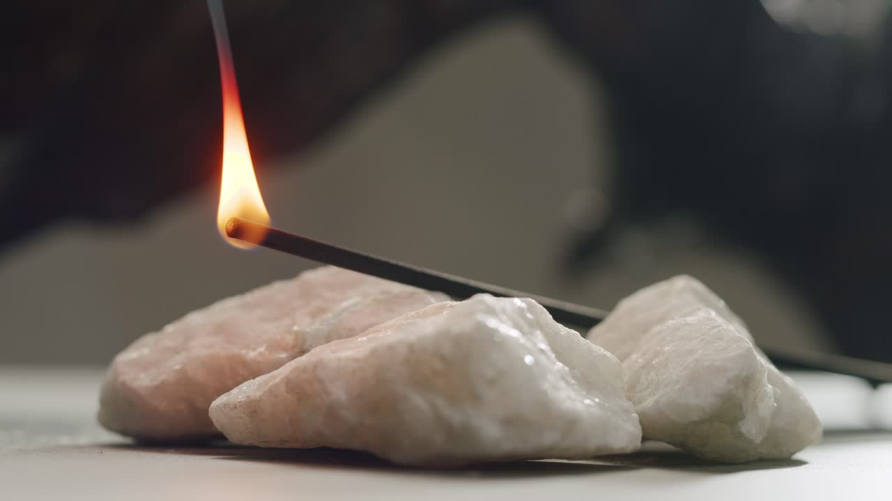 Person holding Palo Santo wood stick in hand, aromatic Palo Santo burning on black background, smoke spreading around, slow motion video clip, high quality 4k close up footage. High quality 4k footage