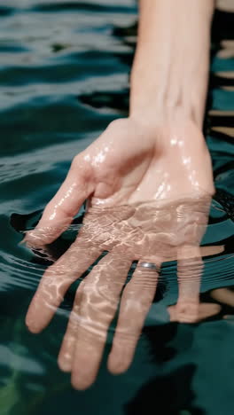 human hand submerged in water with ripples
