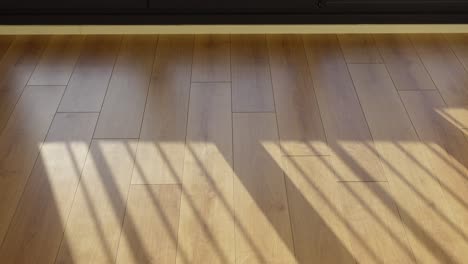 closeup of a wooden floor with sunlight shining through a window, casting shadows