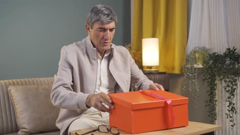 happy and joyful old man opening gift package.