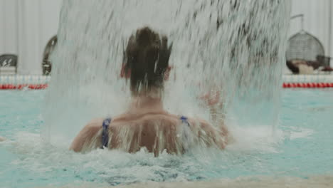 mujer irreconocible nadando en la piscina cubierta
