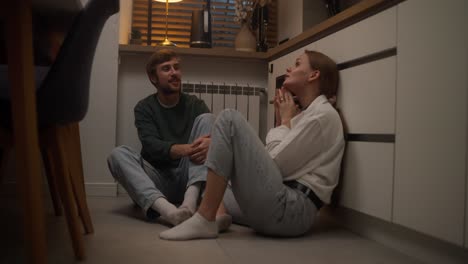 una pareja hablando en la cocina.