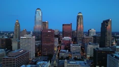 aerial view of urban skyline at dusk with towering skyscrapers and city lights reflecting off glass windows in a vibrant metropolis
