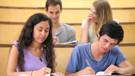 students taking notes while their classmates are chatting