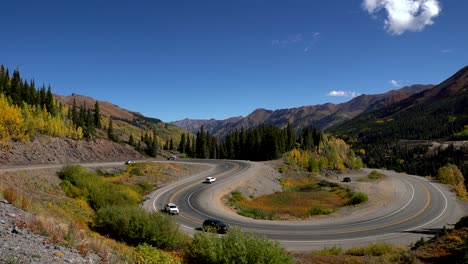 vista de gran ángulo de los coches que viajan en una sección curva de la autopista de un millón de dólares en las montañas de san juan de colorado