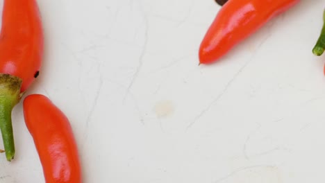 Slow-panning-shot-of-some-fresh-red-chili-peppers-laying-in-a-white-bowl,-close-up