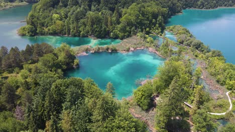 Top-view-of-the-Plitvice-Lakes-National-Park-with-many-green-plants-and-beautiful-lakes,-walking-paths-along-the-forest