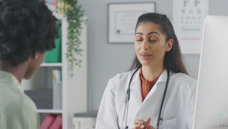 Female-Doctor-Or-Consultant-Wearing-White-Coat-Having-Meeting-With-Female-Patient-In-Office