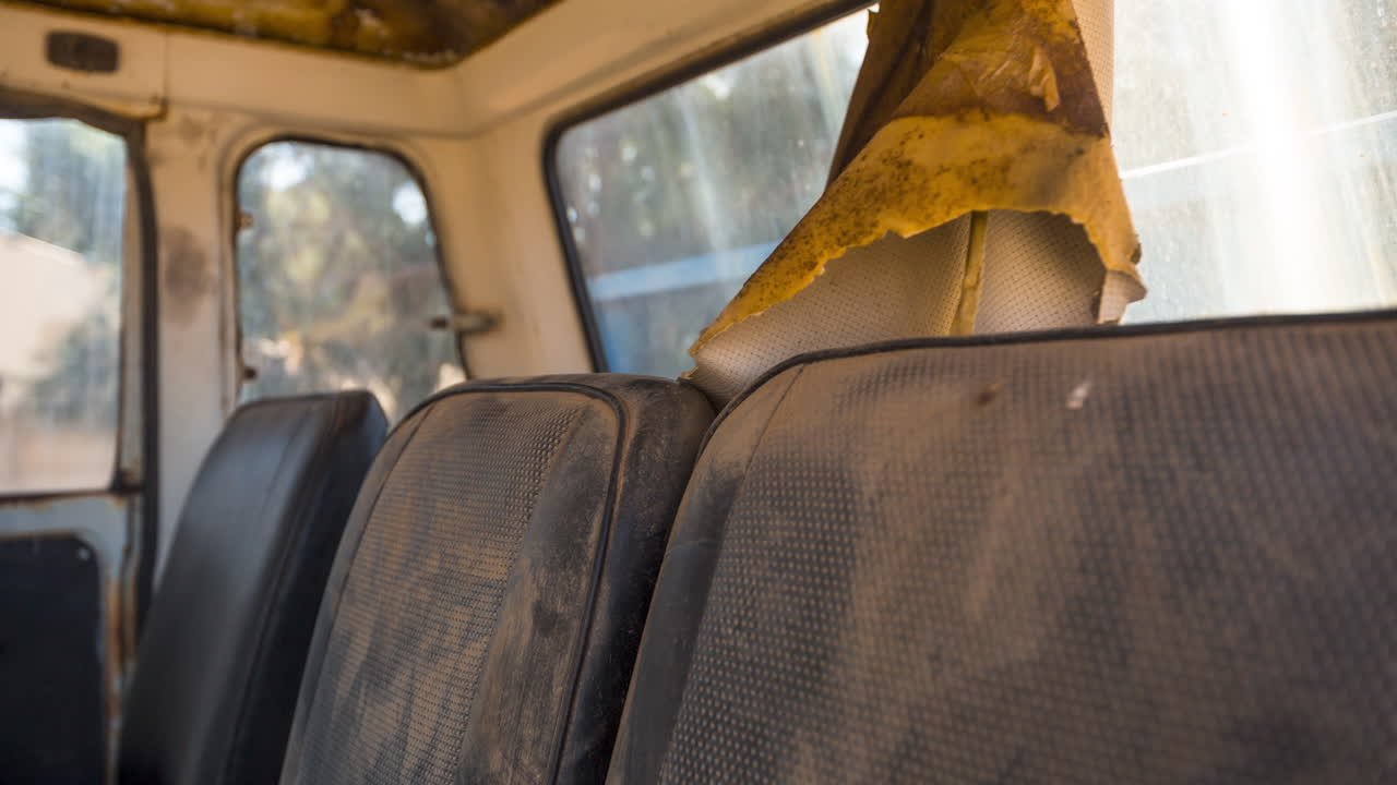 A time-lapse motion shot inside an old abandoned truck that is falling apart