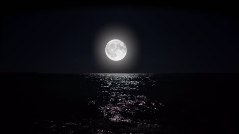 big full moon at night reflecting on the water.