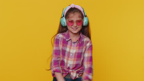 Happy-preteen-child-girl-kid-listening-music-via-headphones-and-dancing-disco-fooling-around